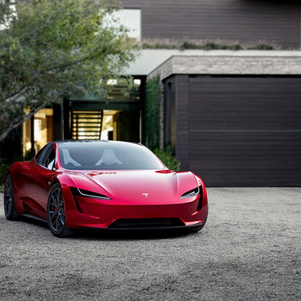 Tesla Roadster Parked in Front of House